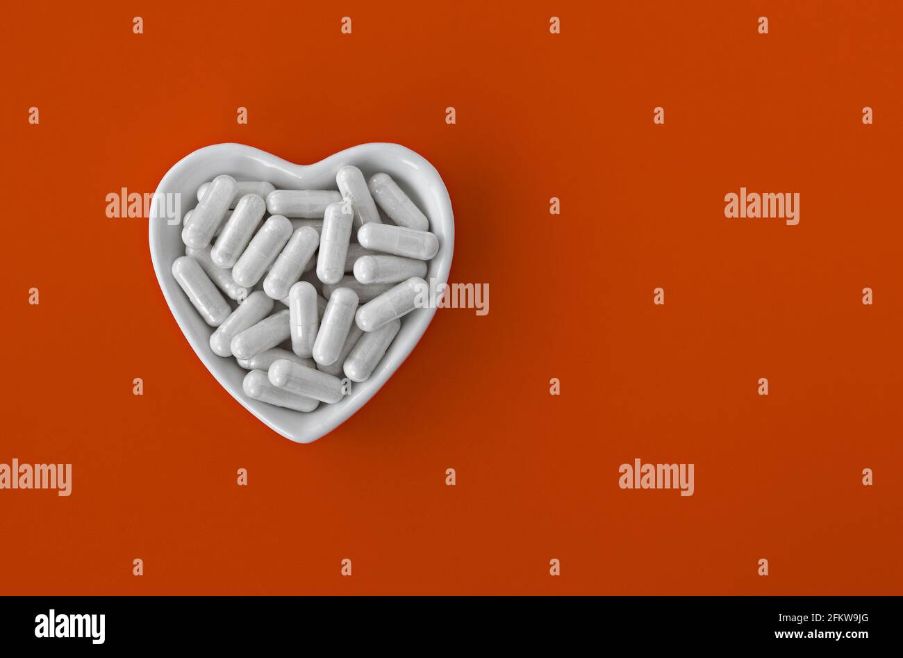 close-up of lithium orotate capsules. dietary concept: an porcelain bowl in the form of a heart full of lithium orotate capsules. dietary supplement t Stock Photo