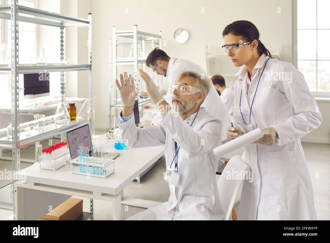 Scientist group in eyewear working at research chemistry medical laboratory Stock Photo