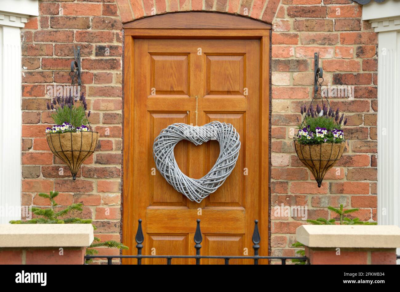 Heart shaped wreath & planters at front door. Stock Photo