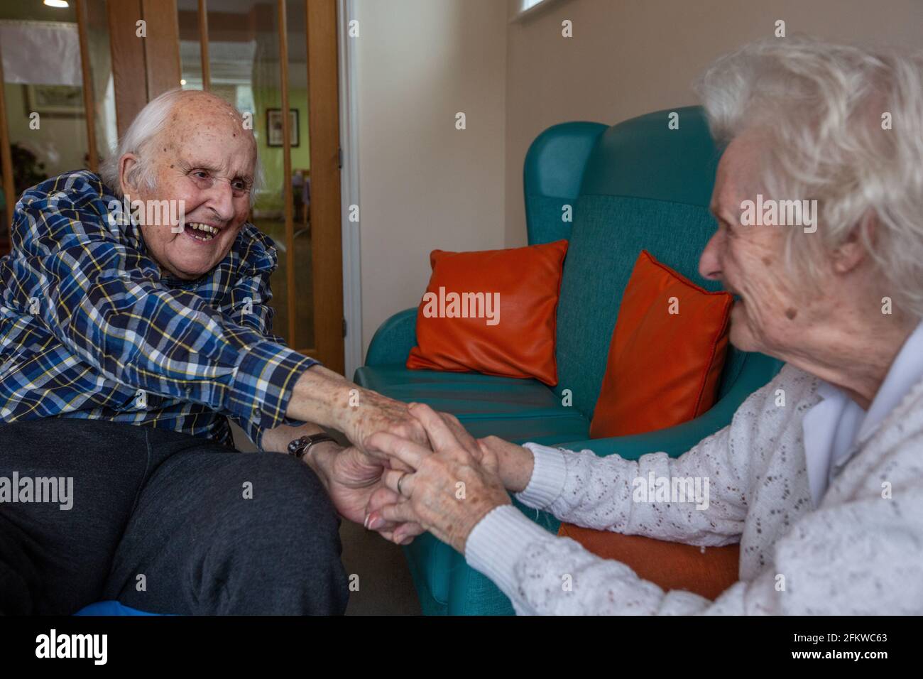 Elderly couple in their eighties reunited in a care come after being separated for several weeks due to the Coronavirus Pandemic, Hampshire, England. Stock Photo