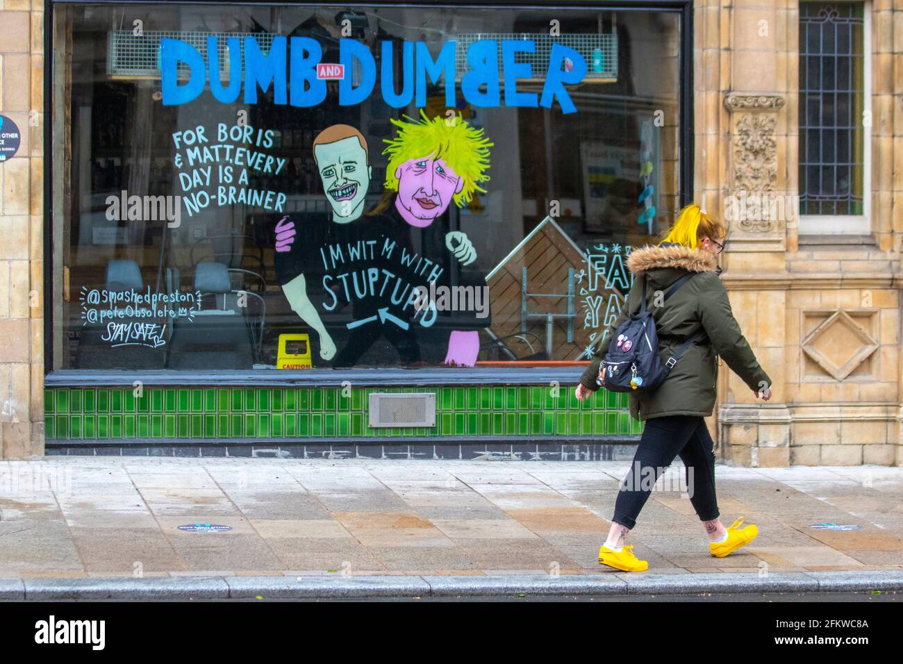 Boris Johnson Tory leader cartoon images in Preston; Lancashire. May 2021; UK Weather; Anoraks waterproof jackets and rain coats are the order of the day on a cold wet and windy day. Satire, comic, caricatures, satirical political cartoons, parody in the city centre. Stock Photo