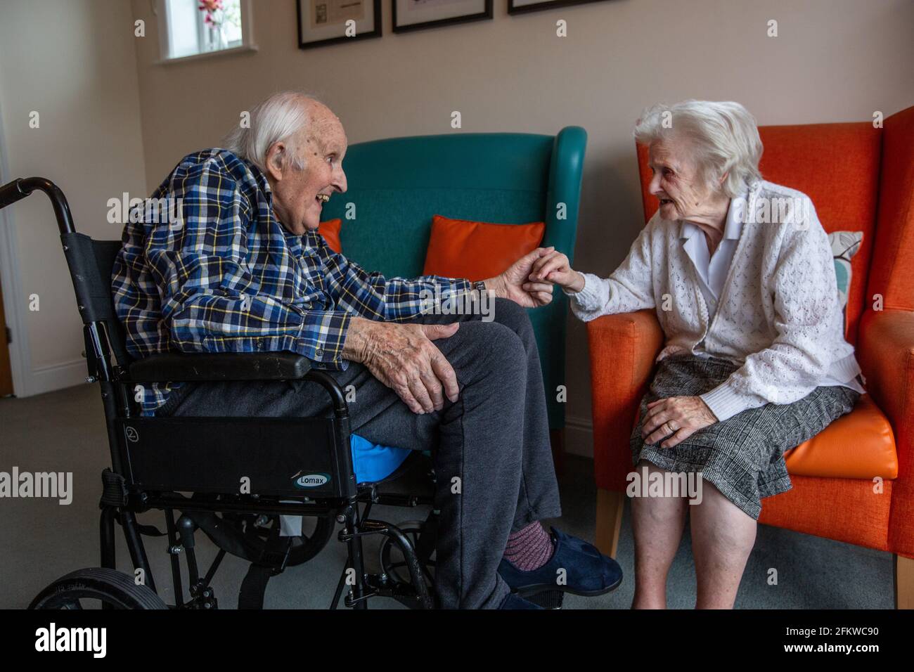 Elderly couple in their eighties reunited in a care come after being separated for several weeks due to the Coronavirus Pandemic, Hampshire, England. Stock Photo