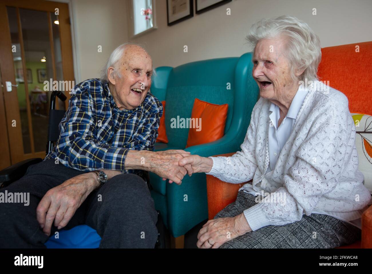 Elderly couple in their eighties reunited in a care come after being separated for several weeks due to the Coronavirus Pandemic, Hampshire, England. Stock Photo