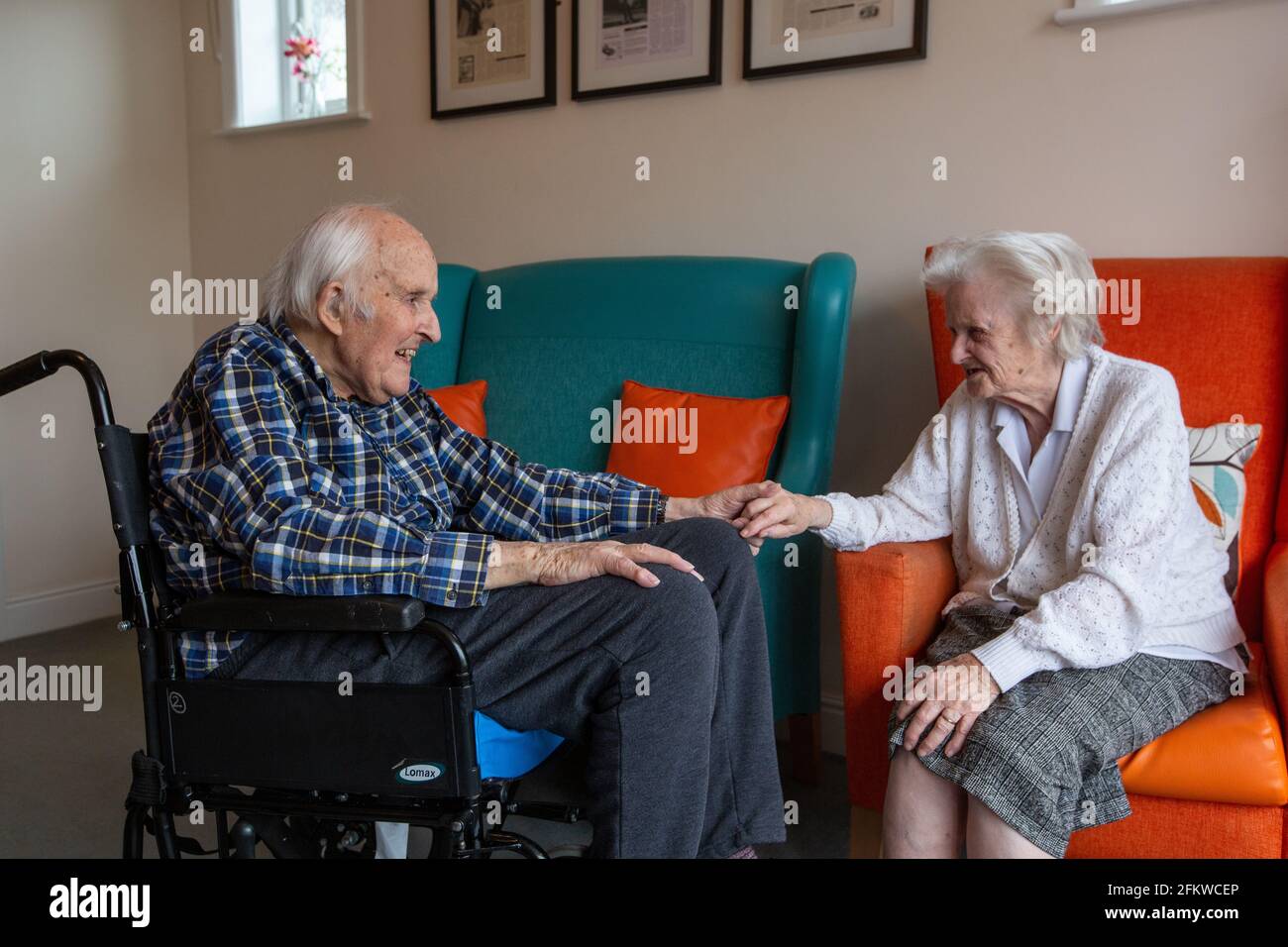 Elderly couple in their eighties reunited in a care come after being separated for several weeks due to the Coronavirus Pandemic, Hampshire, England. Stock Photo