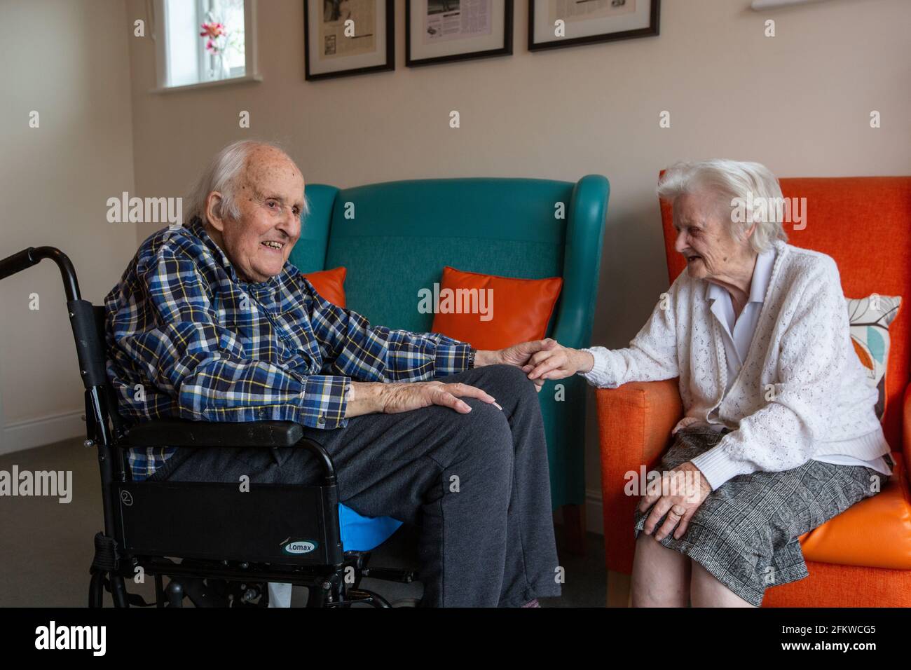 Elderly couple in their eighties reunited in a care come after being separated for several weeks due to the Coronavirus Pandemic, Hampshire, England. Stock Photo