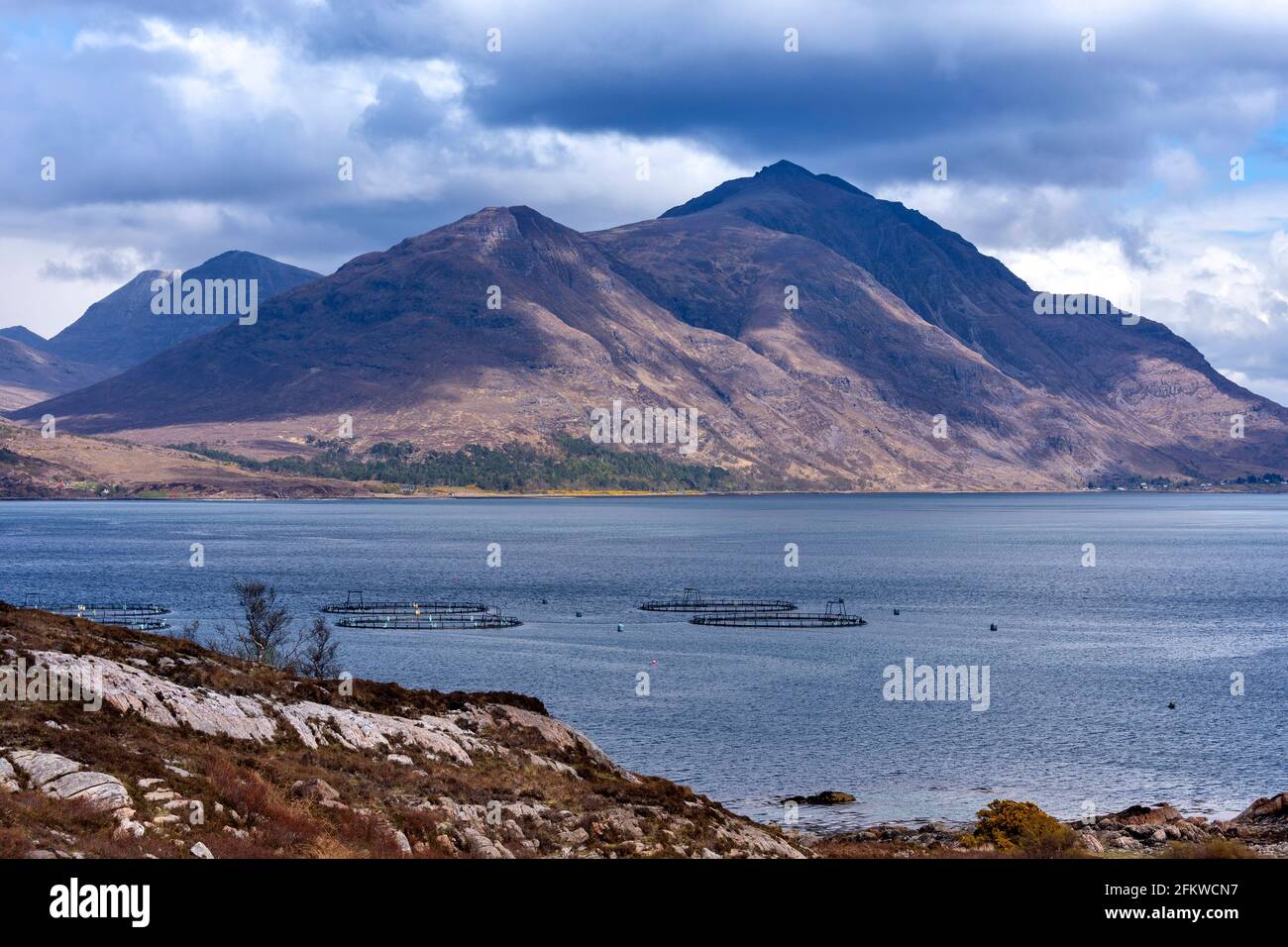 SHIELDAIG WESTER ROSS HIGHLANDS SCOTLAND MOUNTAINS AND SALMON FARM FISH CAGES IN UPPER LOCH TORRIDON Stock Photo