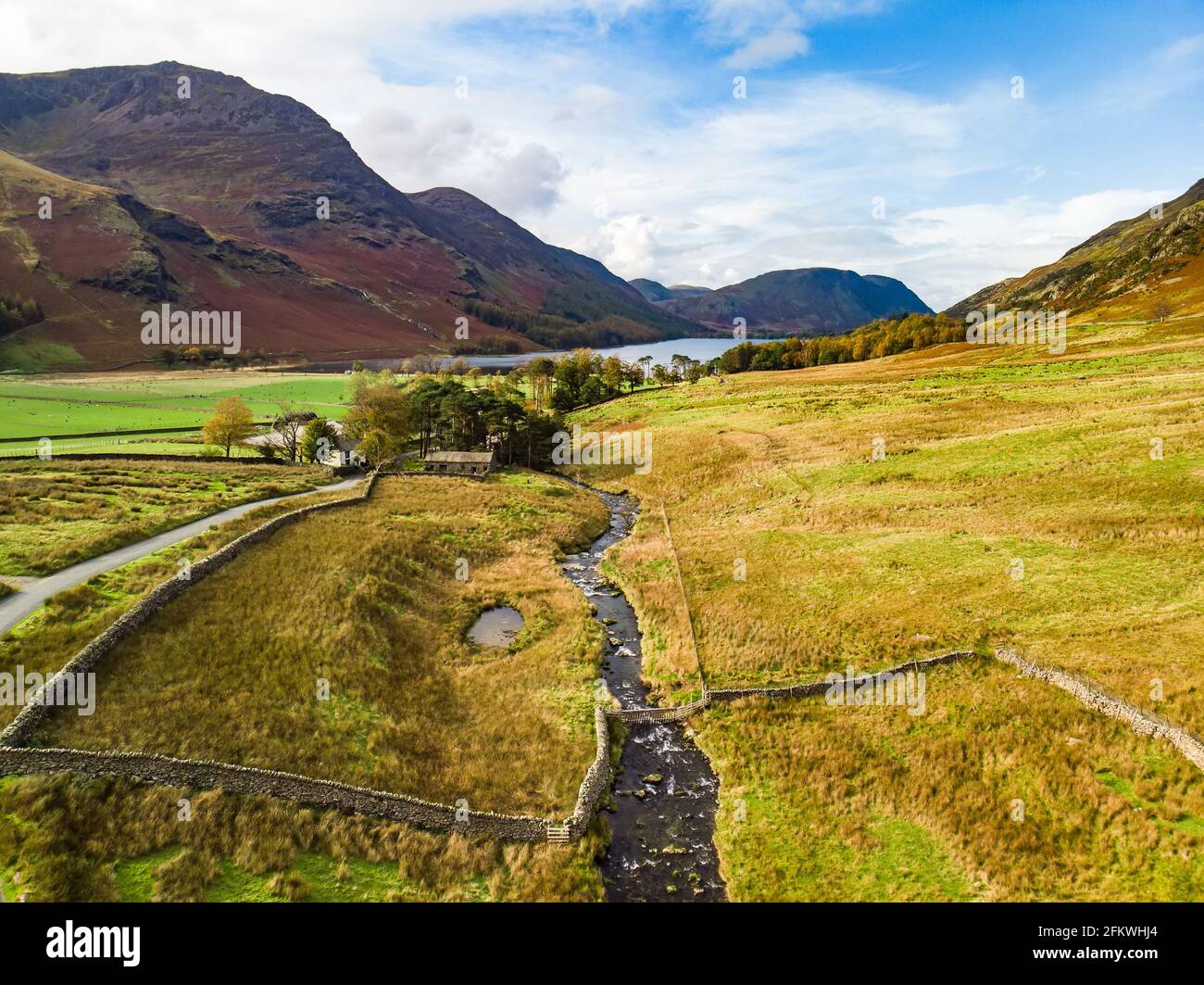 Aerial view of Honister Pass, a mountain pass with a road winding along Gatesgarthdale Beck mountain stream. One of the steepest and highest passes in Stock Photo