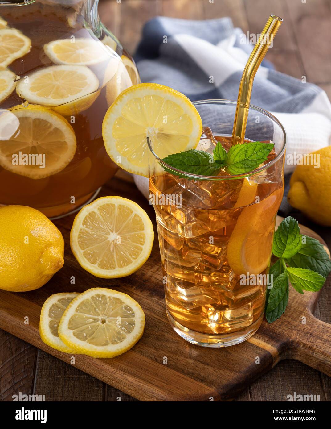 https://c8.alamy.com/comp/2FKWNMY/glass-of-iced-tea-and-pitcher-with-lemon-slices-on-a-wooden-table-2FKWNMY.jpg