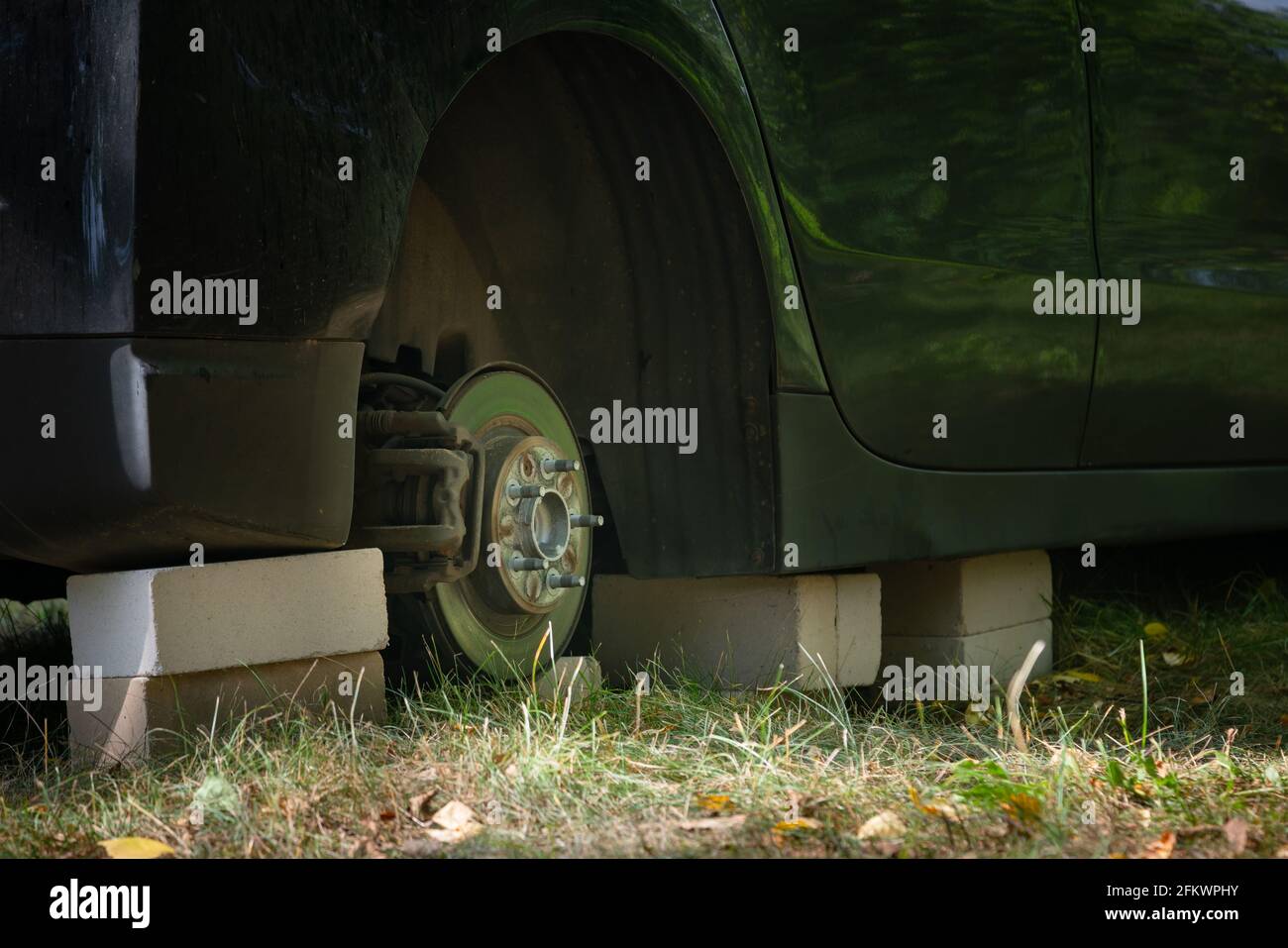 Close up of car on bricks outside. Concept of stolen vehicle wheels