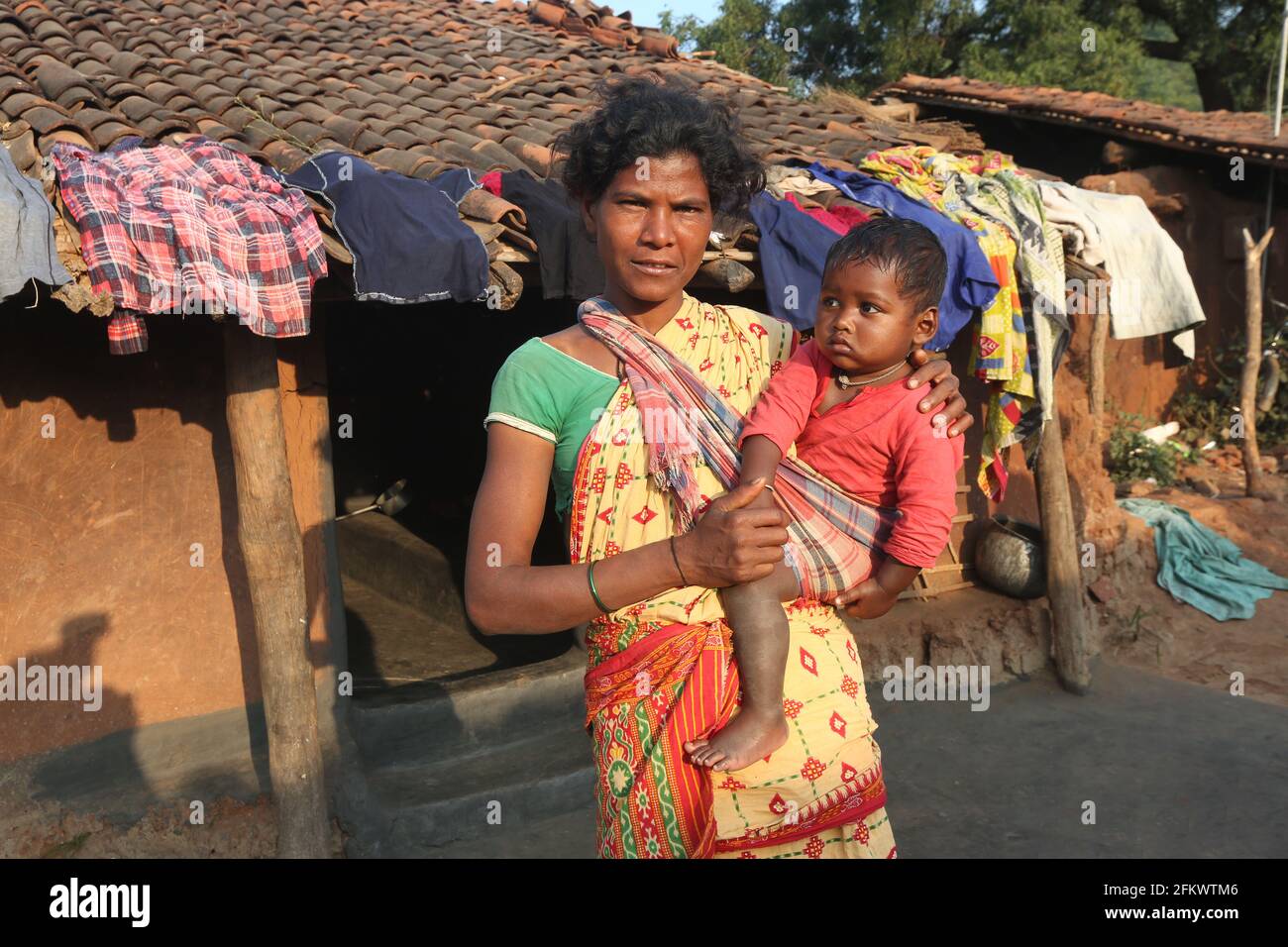 Mother and Child, DESIA KONDHA TRIBE. Standing outside house. Odisha, India Stock Photo