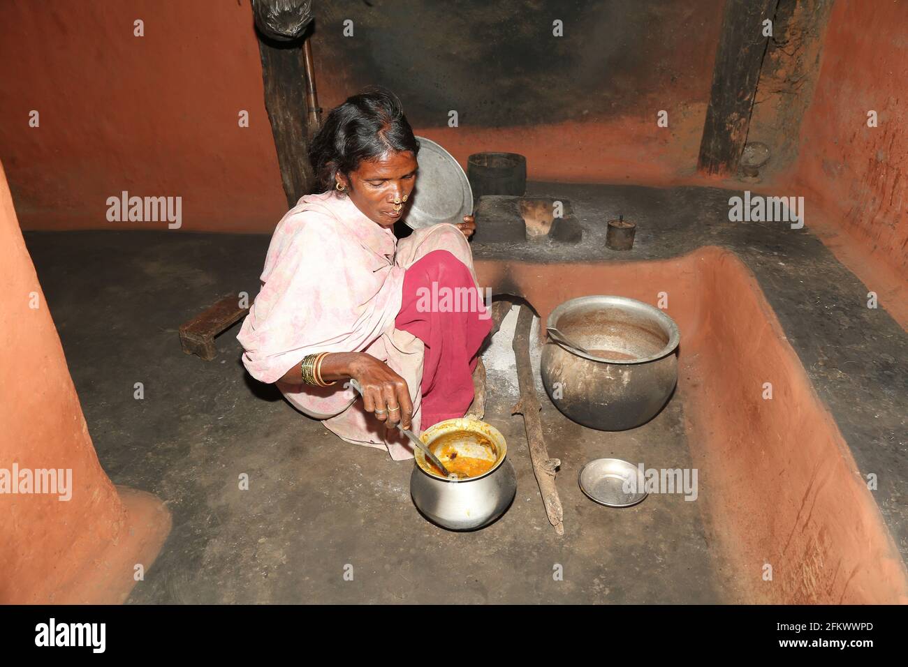 Tribal woman preparing her daily meals in her kitchen at Lanjigadh village in Odisha, India. DESIA KONDHA TRIBE Stock Photo