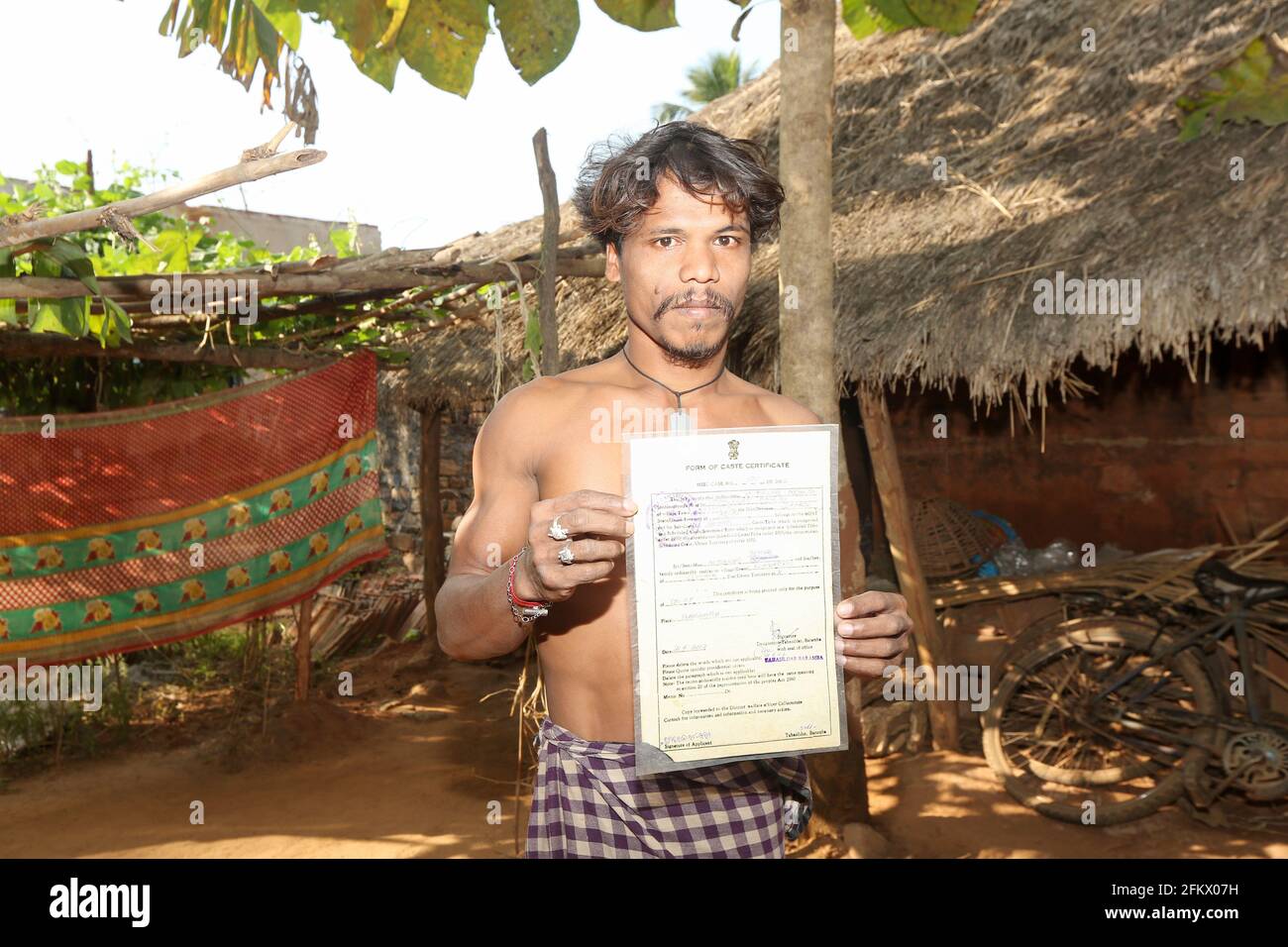 Young Farmer showing his caste certificate at Kuanarpal village of Cuttack district of Odisha, India Stock Photo