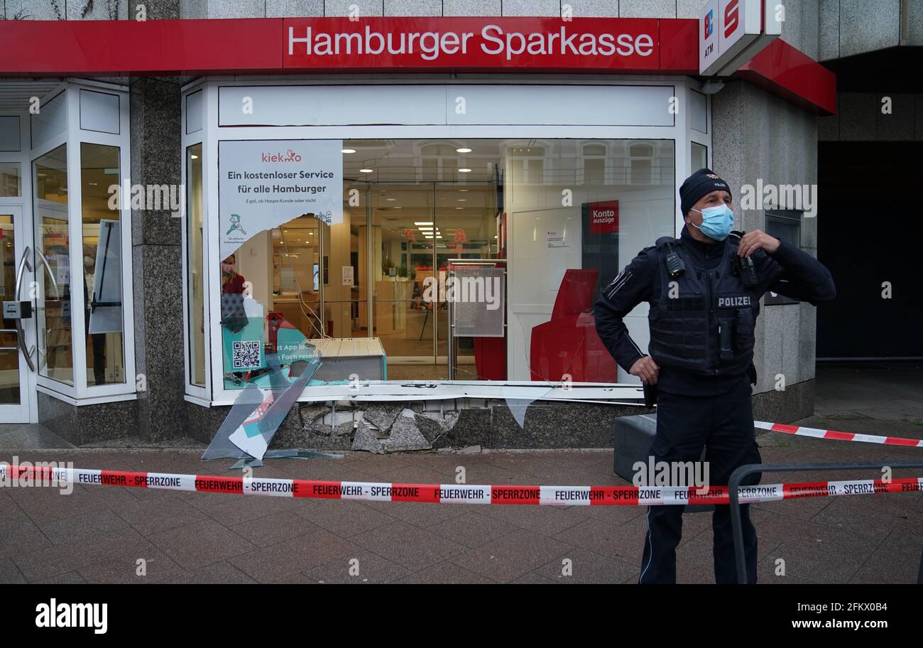 Hamburg, Germany. 04th May, 2021. A policeman stands in front of the window of a Haspa branch that was destroyed in an accident. In Waitzstraße in Hamburg, which is known for numerous 'shop window accidents', a car has once again crashed into the window of a shop. On Tuesday, a 73-year-old woman lost control of her car and crashed it into the building housing the Hamburg savings bank Haspa, a police spokesman told the Deutsche Presse-Agentur in Hamburg. Credit: Marcus Brandt/dpa/Alamy Live News Stock Photo