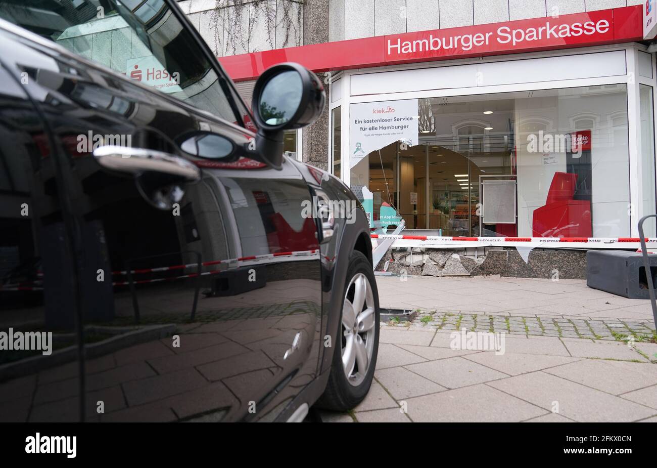 Hamburg, Germany. 04th May, 2021. The vehicle involved in the accident is standing in front of the destroyed shop window of a Haspa branch. In Waitzstraße in Hamburg, which is known for numerous 'shop window accidents', a car has once again crashed into the window of a shop. On Tuesday, a 73-year-old woman had lost control of her car and crashed it into the building housing the Hamburg savings bank Haspa, a police spokesman told the Deutsche Presse-Agentur in Hamburg. Credit: Marcus Brandt/dpa/Alamy Live News Stock Photo