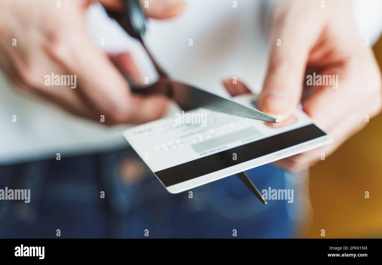 Woman cuts credit card with scissors. Stock Photo