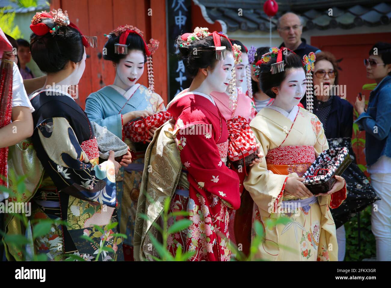 Geisha and maiko women wearing beautiful and elegant kimono dress and costume walking through Gion, Higashiyama, Kyoto, Japan. Stock Photo