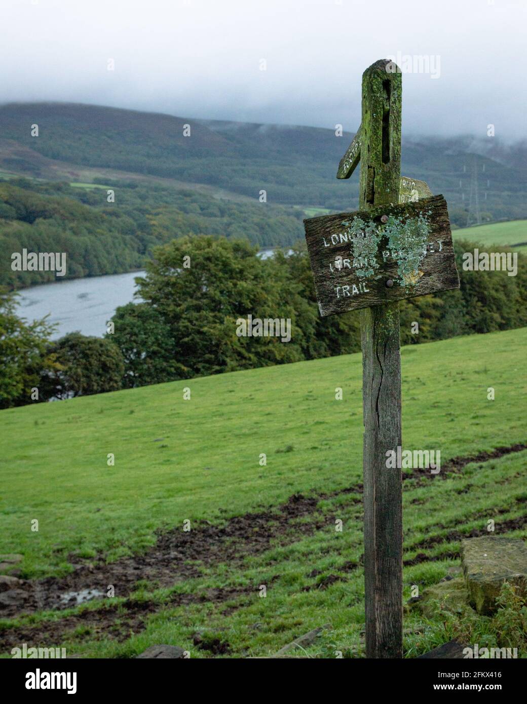 A signpost for the transpennine trail in a field by Valehouse Reservoir in the Peak District National Park, Derbyshire, UK Stock Photo