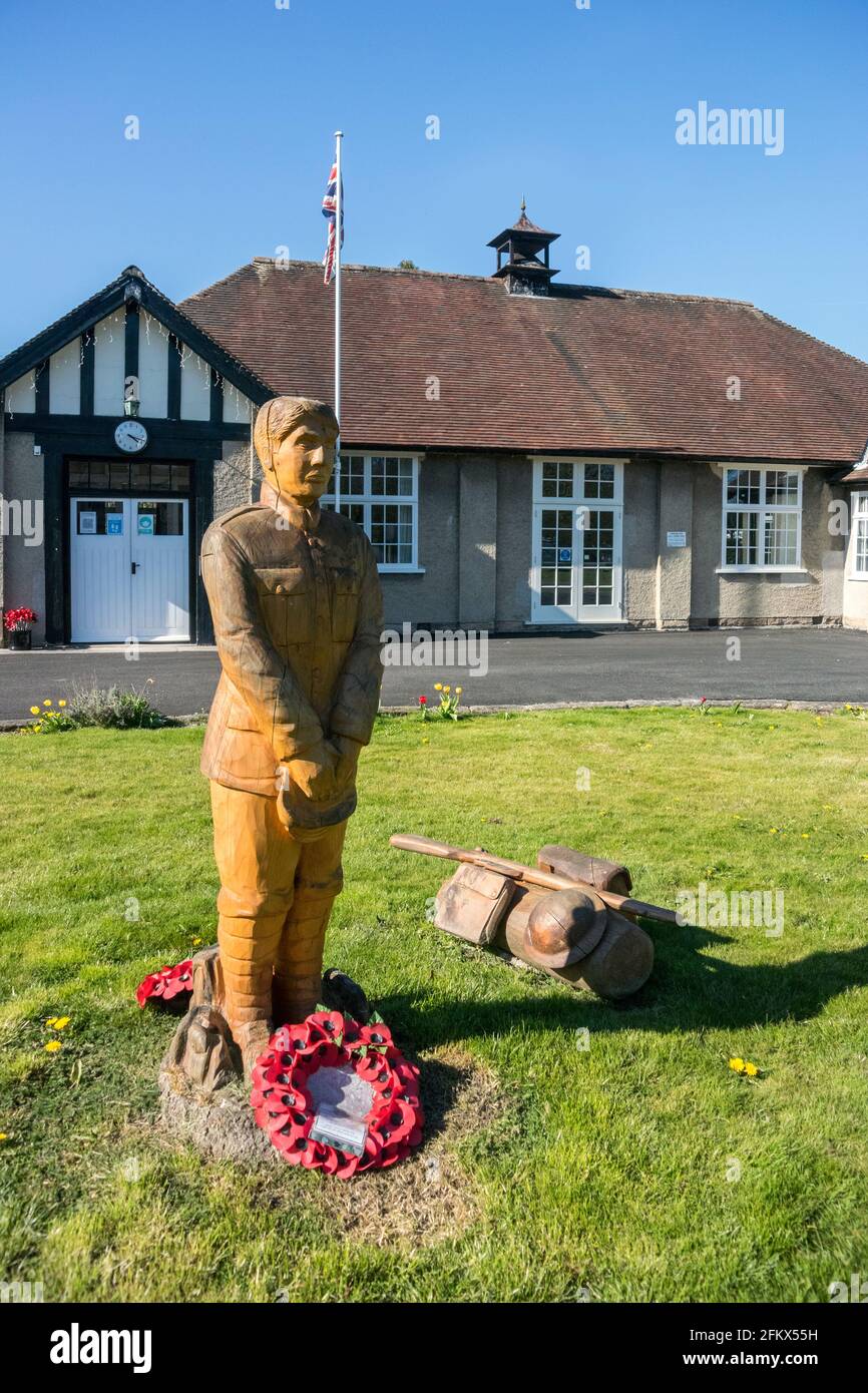 War Memorial Soldier, carved from in-situ tree stump, and War Memorial Institute, Ashford-in-the-Water, Derbyshire Stock Photo