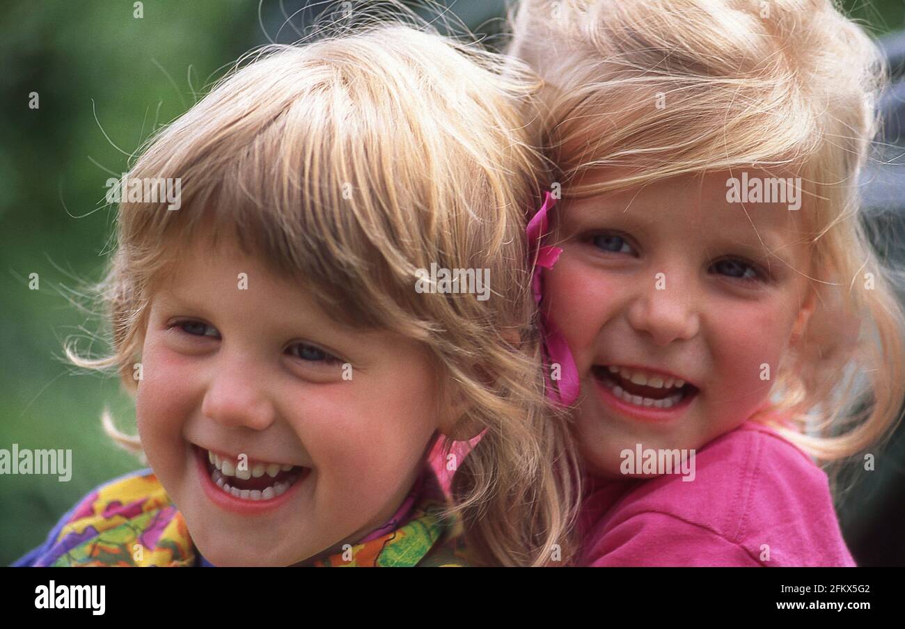 Young sisters hugging and laughing, Berkshire, England, United Kingdom Stock Photo