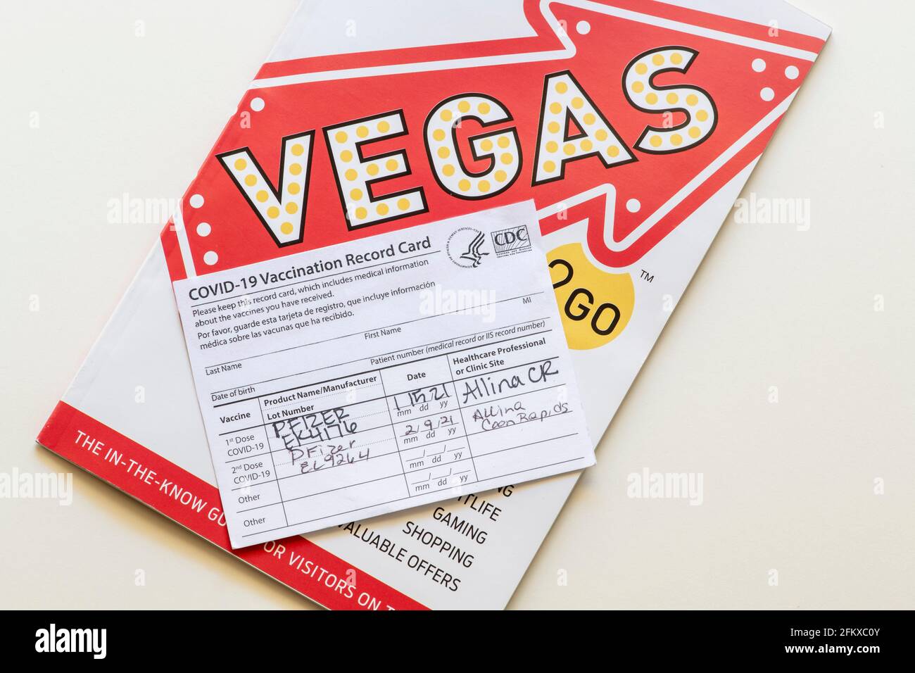 Minnesota; USA.  Covid-19 vaccination record card with both shots and Vegas travel brochure. Stock Photo
