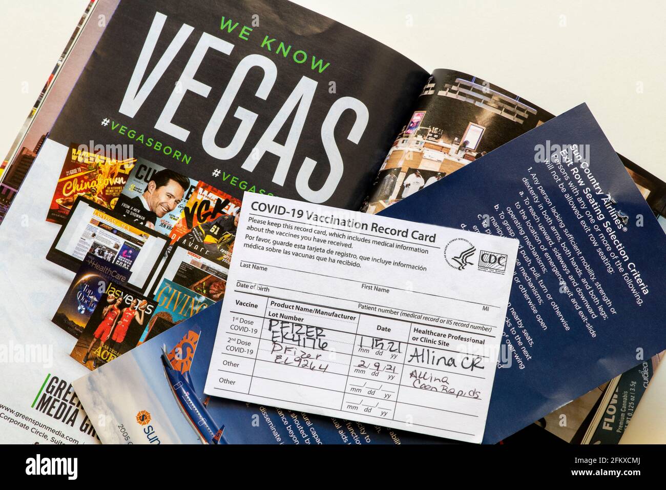 Minnesota; USA.  Covid-19 vaccination record card with both shots and Vegas and airline travel brochures. Stock Photo