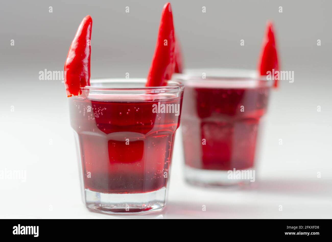 Drink shot prepared with vodka, grenadine and lemon juice decorated