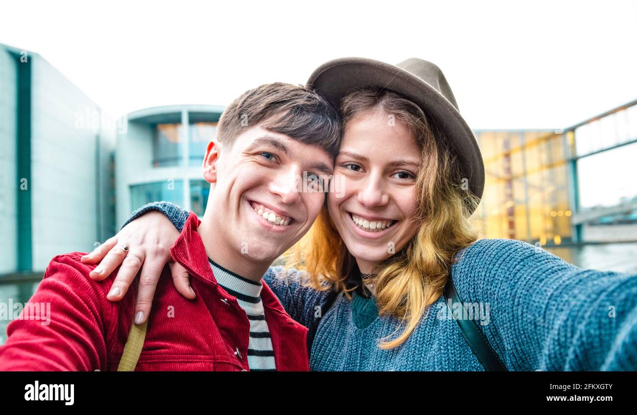 Happy boyfriend and girlfriend in love having genuine fun taking selfie at modern area in Berlin - Teenagers life style and travel concept with young Stock Photo