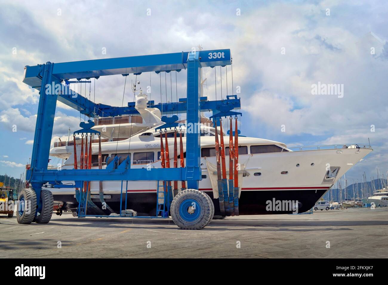 Large yacht being moved to launching slipway by 300 ton boat crane. Stock Photo