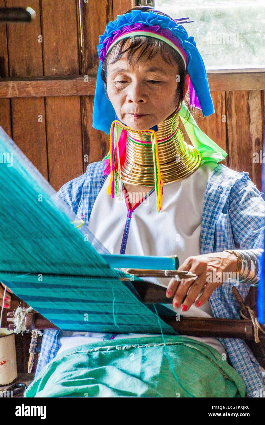 INLE, MYANMAR - NOVEMBER 28, 2016: Kayan long neck woman is weaving a fabric in a workshop at Inle lake, Myanmar Stock Photo