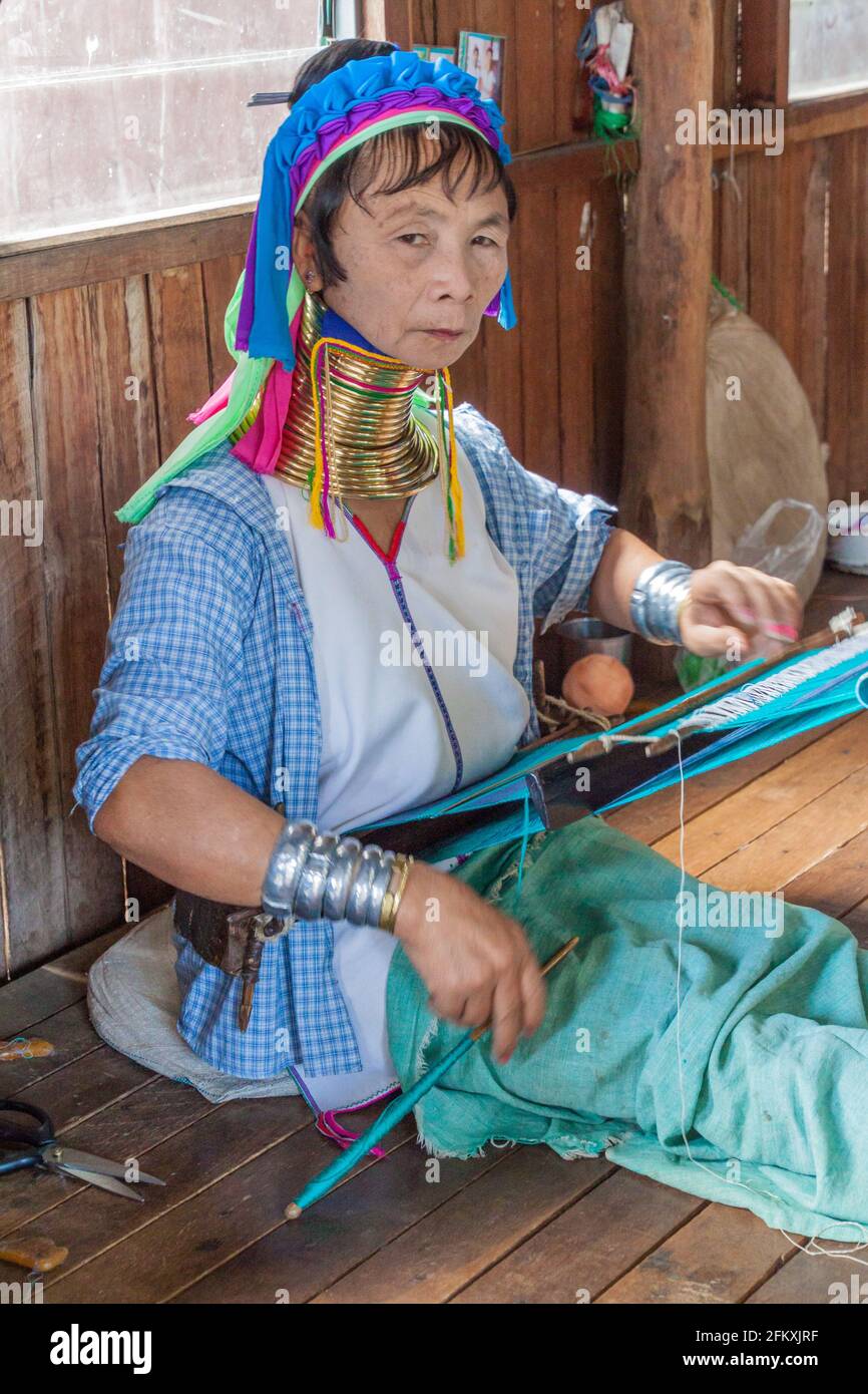 INLE, MYANMAR - NOVEMBER 28, 2016: Kayan long neck woman is weaving a fabric in a workshop at Inle lake, Myanmar Stock Photo