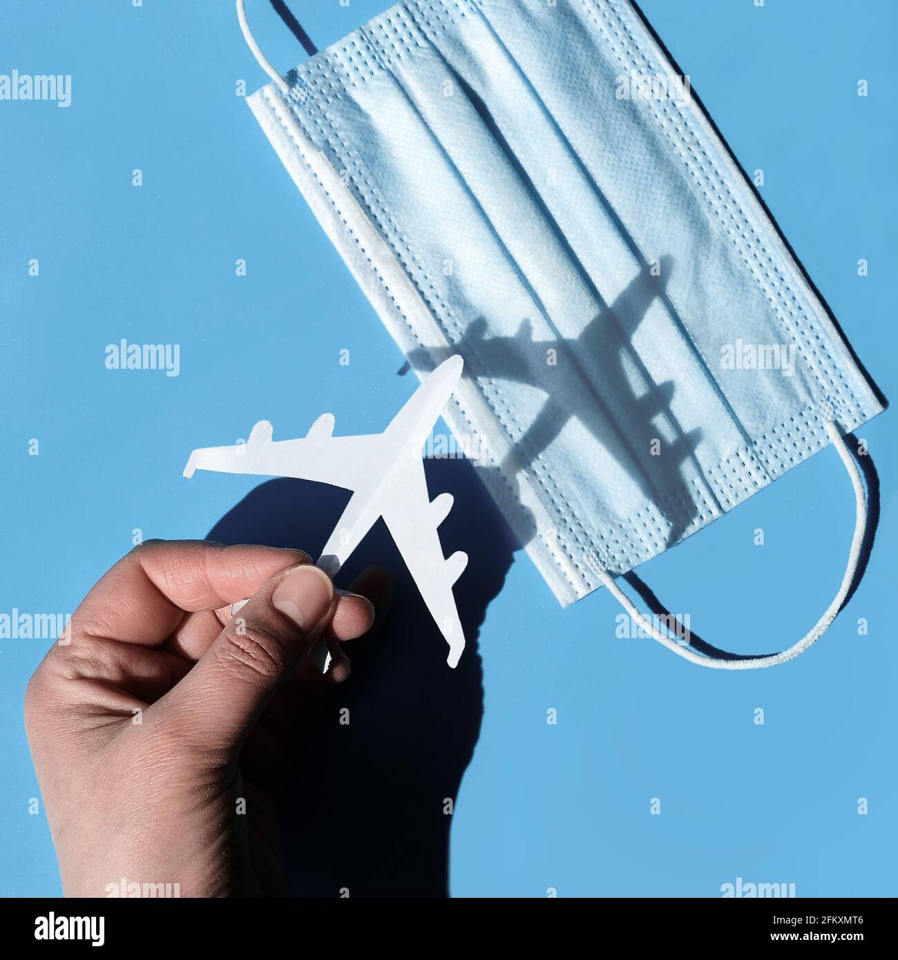 Air travel after lockdown. Hand hold paper plane flying it over medical