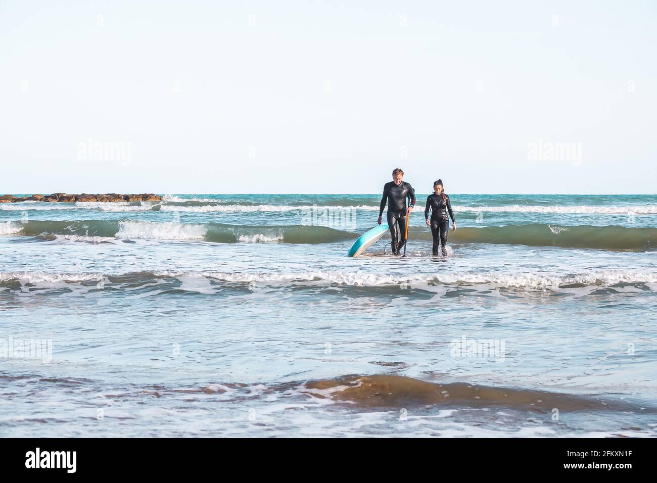 Couple of surfers coming out of the water in Benicasim beach Spain Stock Photo