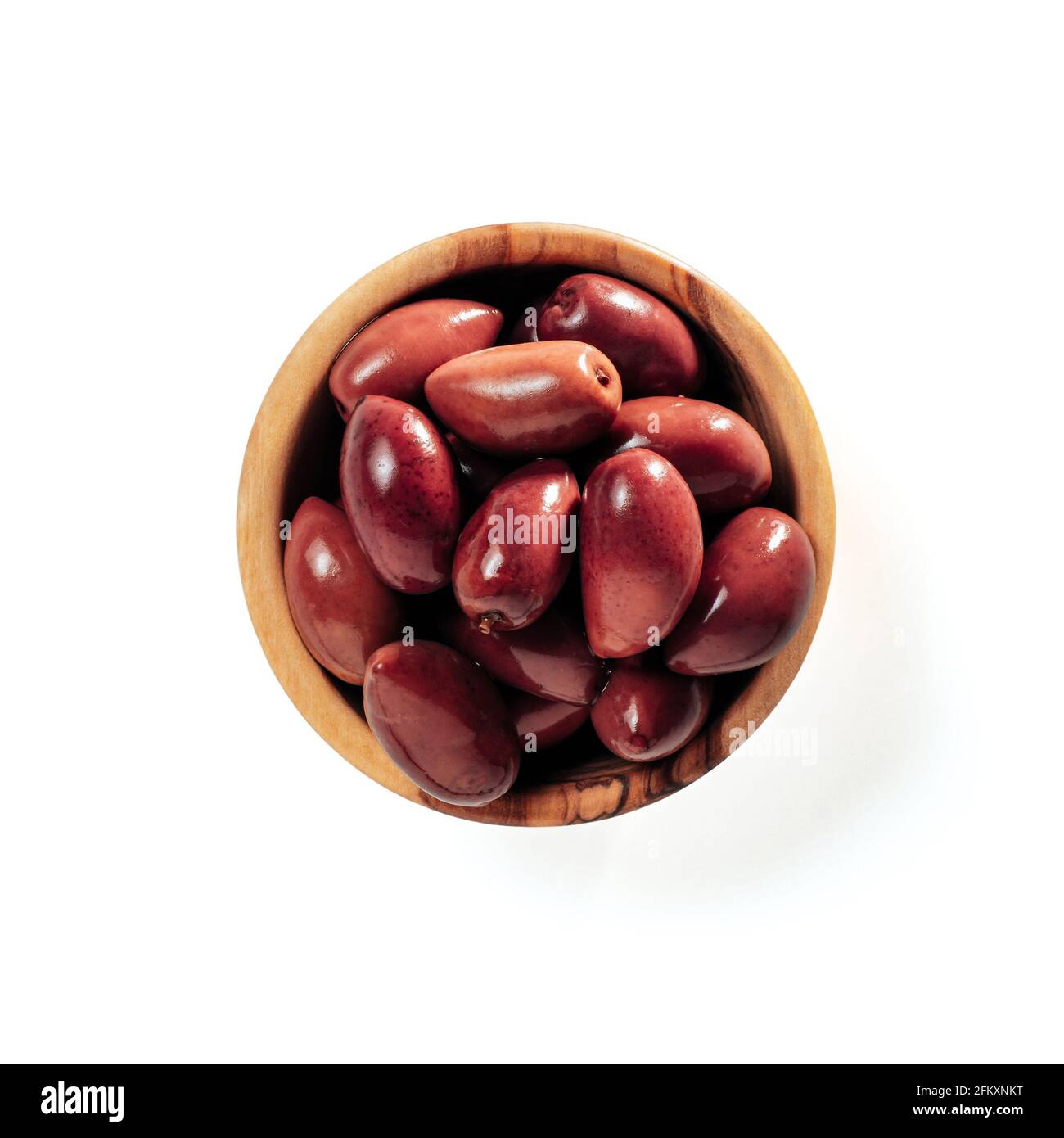 Small wooden bowl with red kalmata olives isolated on white background. Flat lay or top view of small beautiful olive tree bowl with full red olives, isolated with clipping path Stock Photo