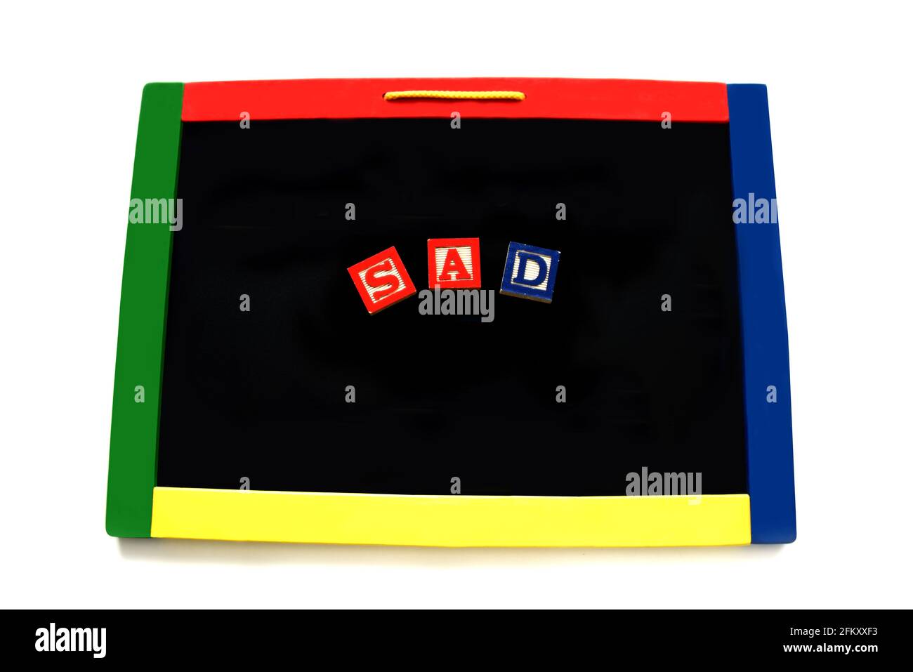 Wooden block letters spell the word sad on a magnetic board.  Image could represent an unhappy child, parent or other adult. Board is rimmed with prim Stock Photo