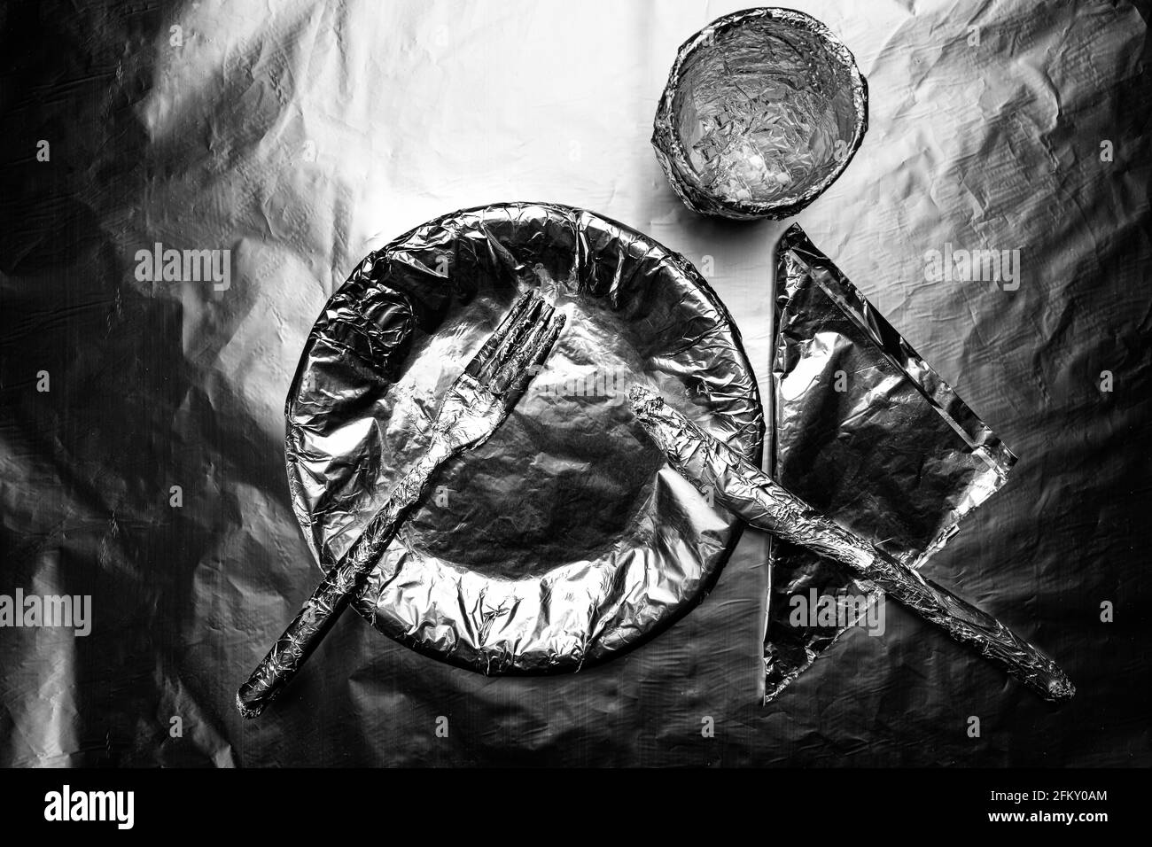 home plate, crockery and a glass covered with aluminum foil Stock Photo