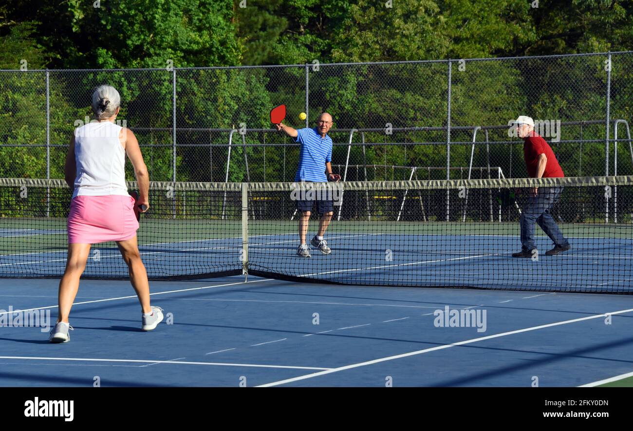Two senior men double up against a woman in a competitive game of