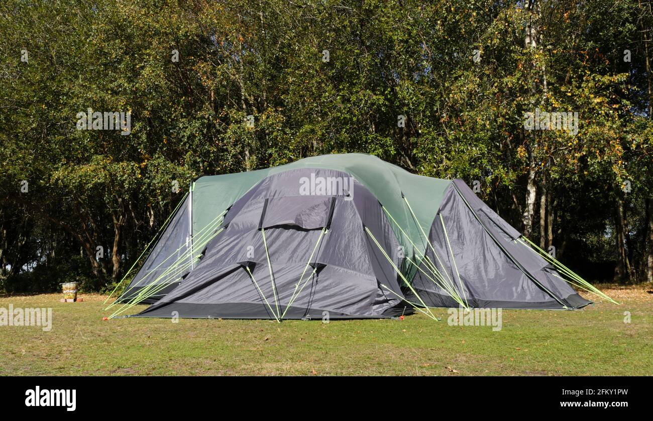 Navy blue and green large family tent in camping field , on the edge of plain in the New Forest National Park , United Kingdom . Stock Photo