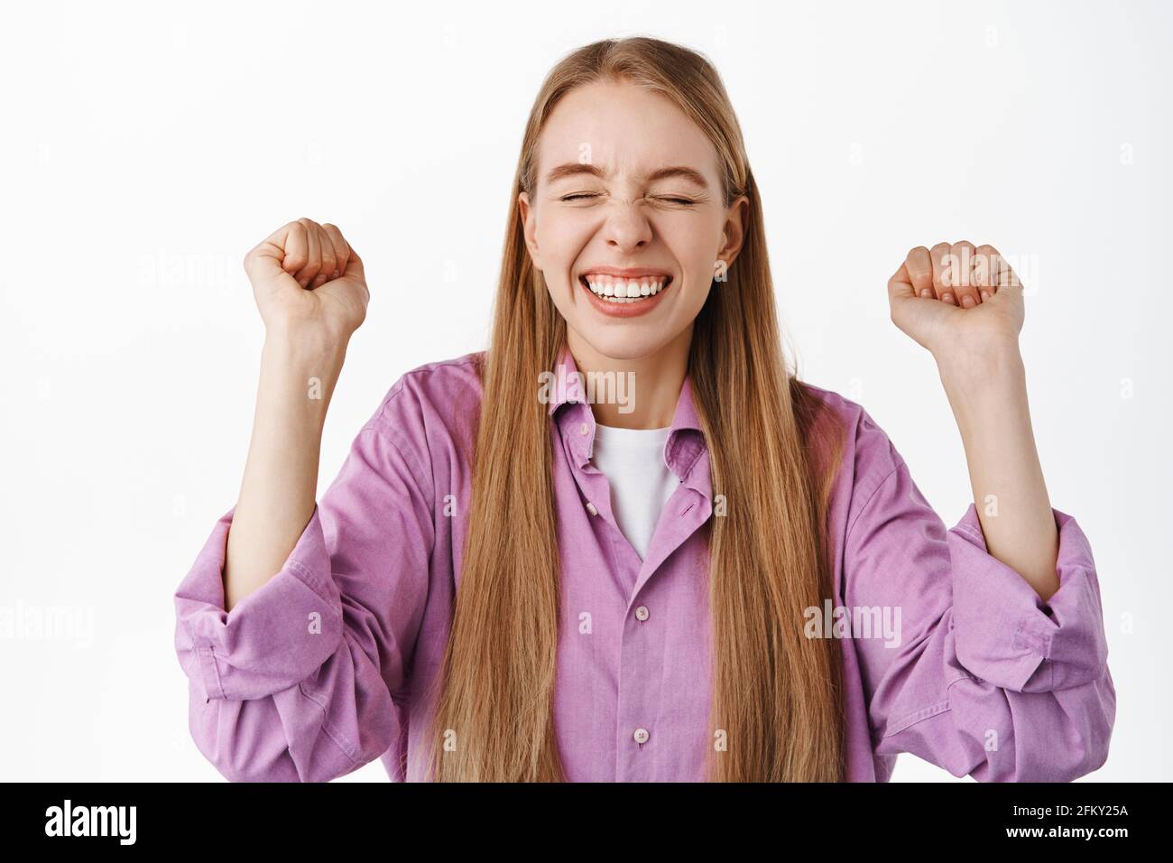 Successful happy blond girl rejoicing, say yes, making fist pump and ...