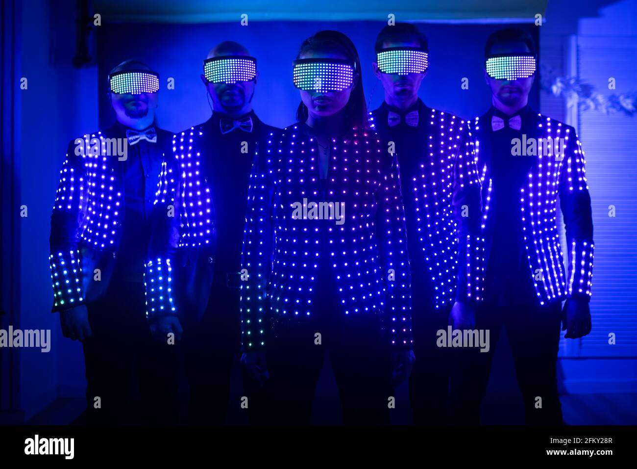 dance team in LED suits on a dark background Stock Photo