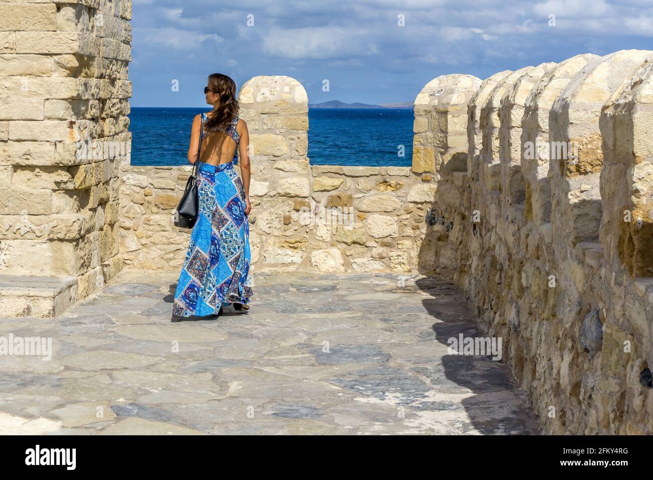 Heraklion, Crete Island, Greece. A young woman in blue dress on the roof of Koules fortress admires the view of the sea. Sunny day, cloudy blue sky Stock Photo - Alamy Heraklion, Crete Island, Greece. A young woman in blue dress on the roof of Koules fortress admires the view of the sea. Sunny day, cloudy blue sky Stock Photo - Alamy