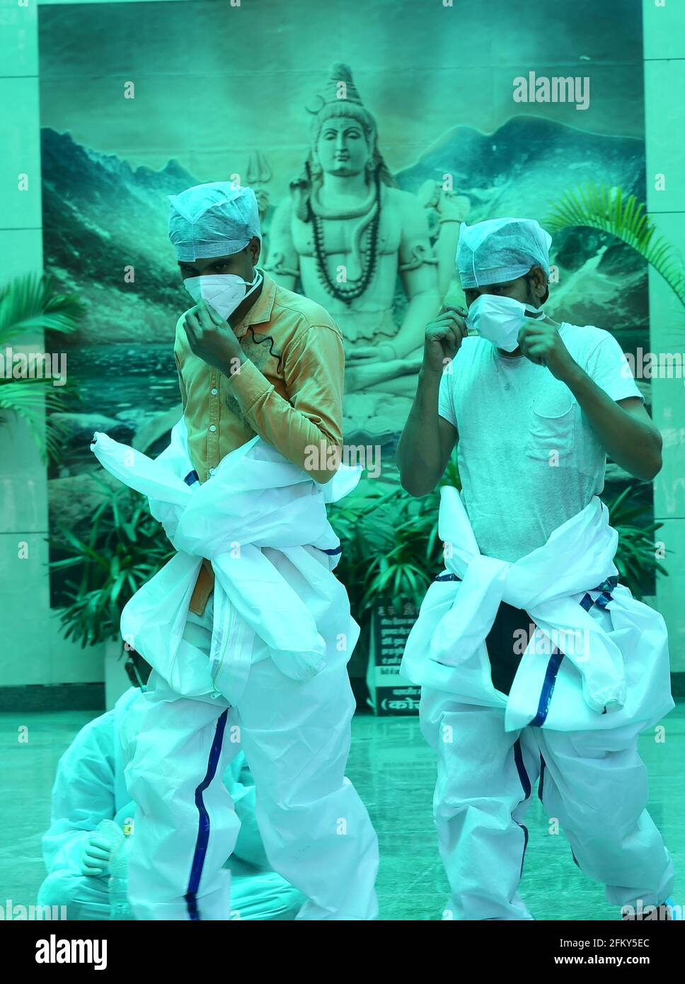 New Delhi, India. 04th May, 2021. Health workers wearing PPE suits prepare to cremate bodies of  COVID-19 victims at a crematorium, in New Delhi, India, Tuesday, May 4, 2021.  More than 20 million Indians have been infected with the coronavirus as it continues to spread with 3,500 deaths in the past 24 hours. Credit: UPI/Alamy Live News Stock Photo