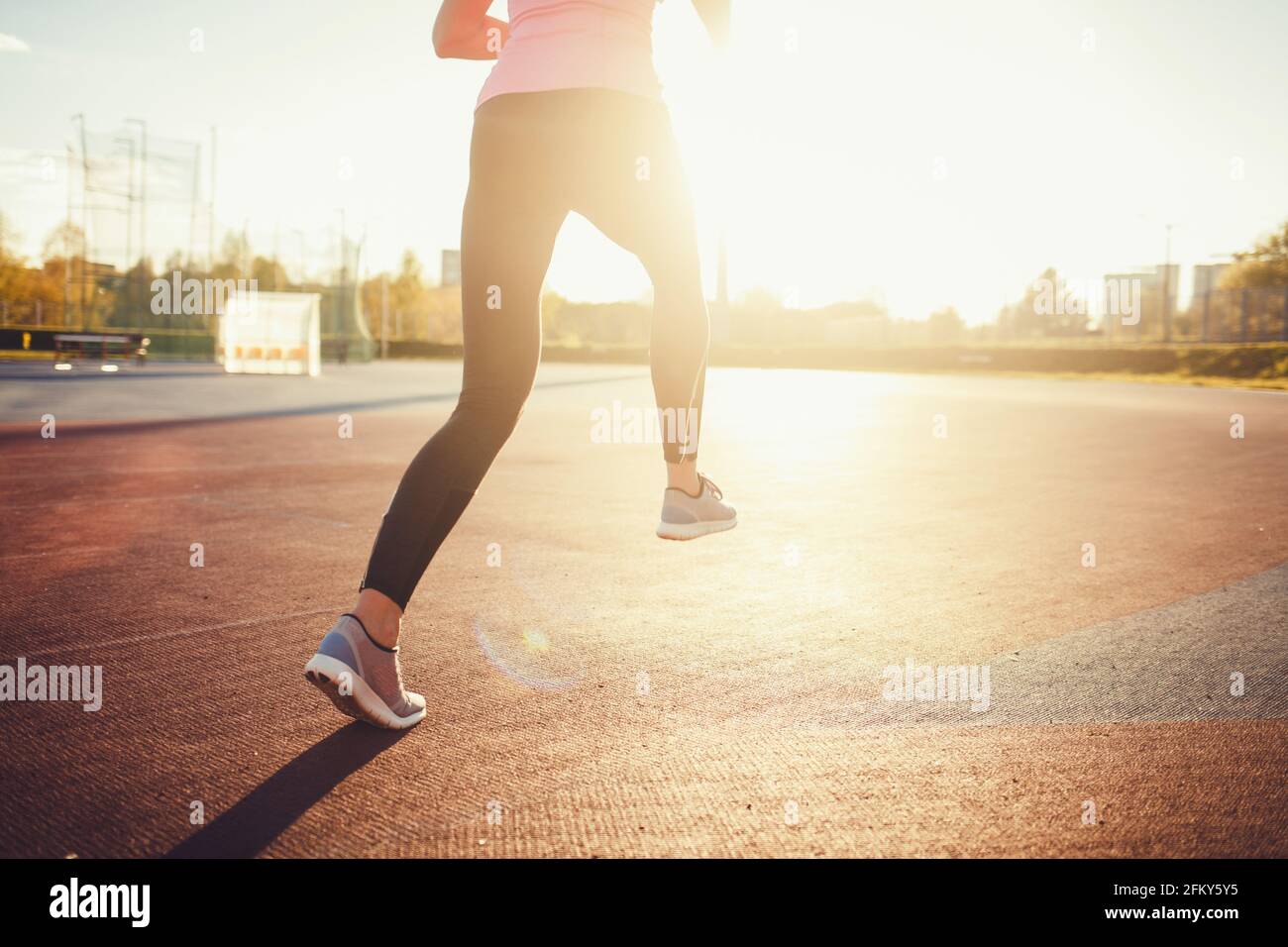 Runner athlete running on road. Woman fitness sunset jogging workout