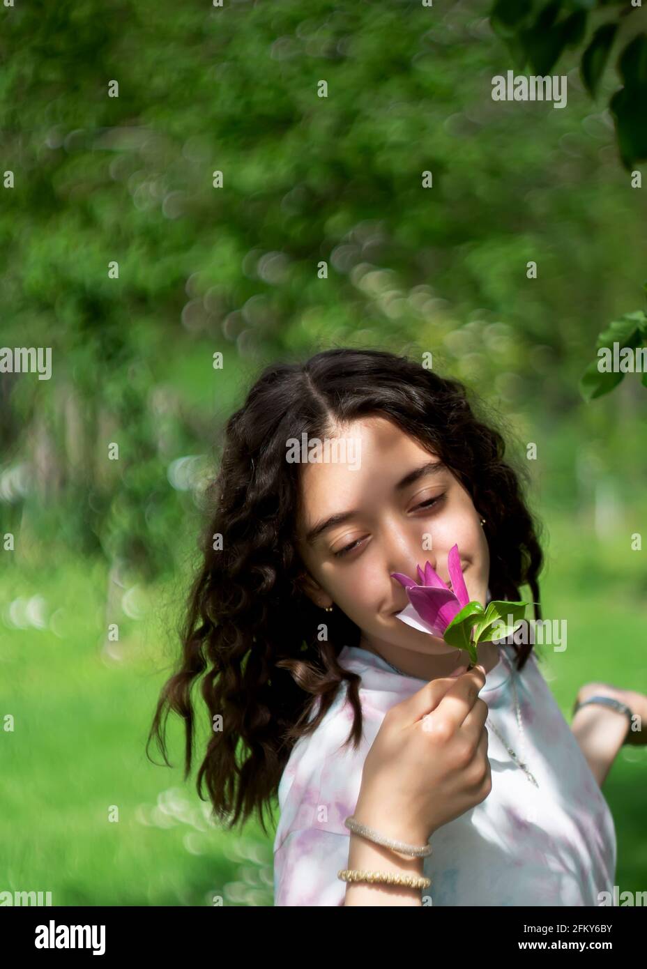Little girl enjoys the smell of flowers in the meadow Stock Photo - Alamy