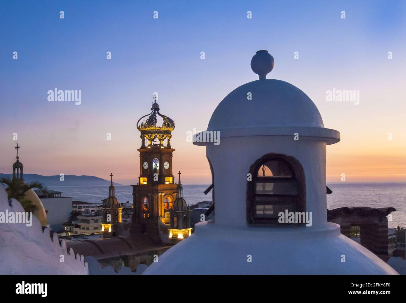 Rooftop cupola and the steeple of Our Lady of Guadalupe Church are icons of colonial urban architecture in “Romantic Zone” of Puerto Vallarta. #613PV Stock Photo