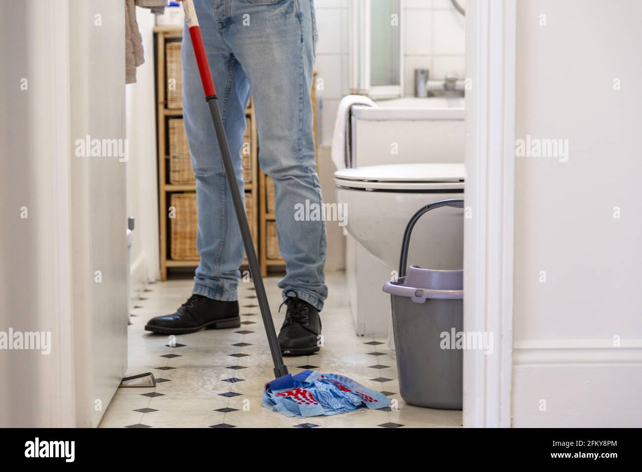 Man mopping the bathroom floor with a mopping stick Stock Photo Alamy