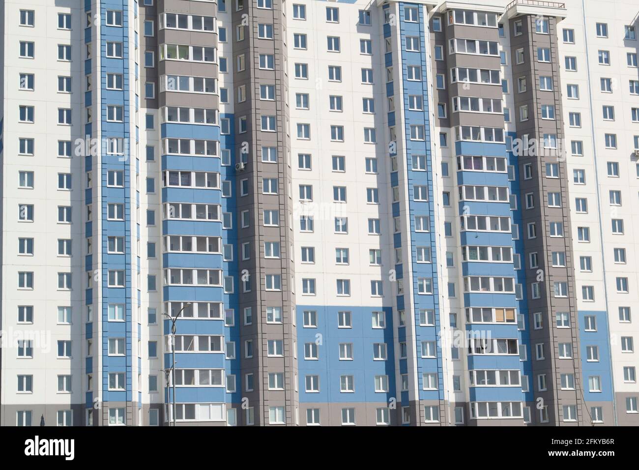 Multiple windows on a large building in the city in blue and white Stock Photo