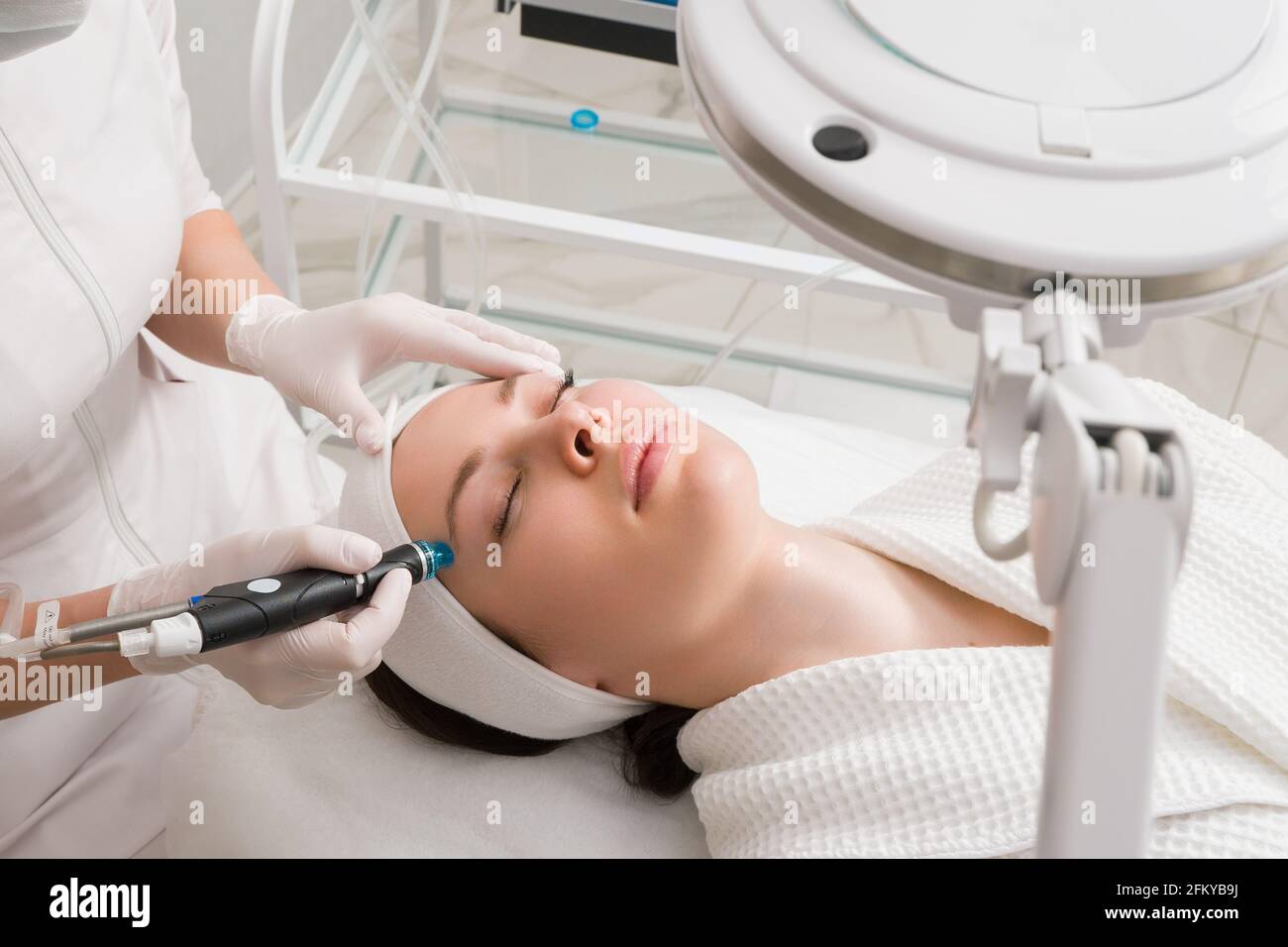 A woman receives laser treatment of the face in a cosmetology clinic, a concept of skin rejuvenation is being developed. laser peeling Stock Photo