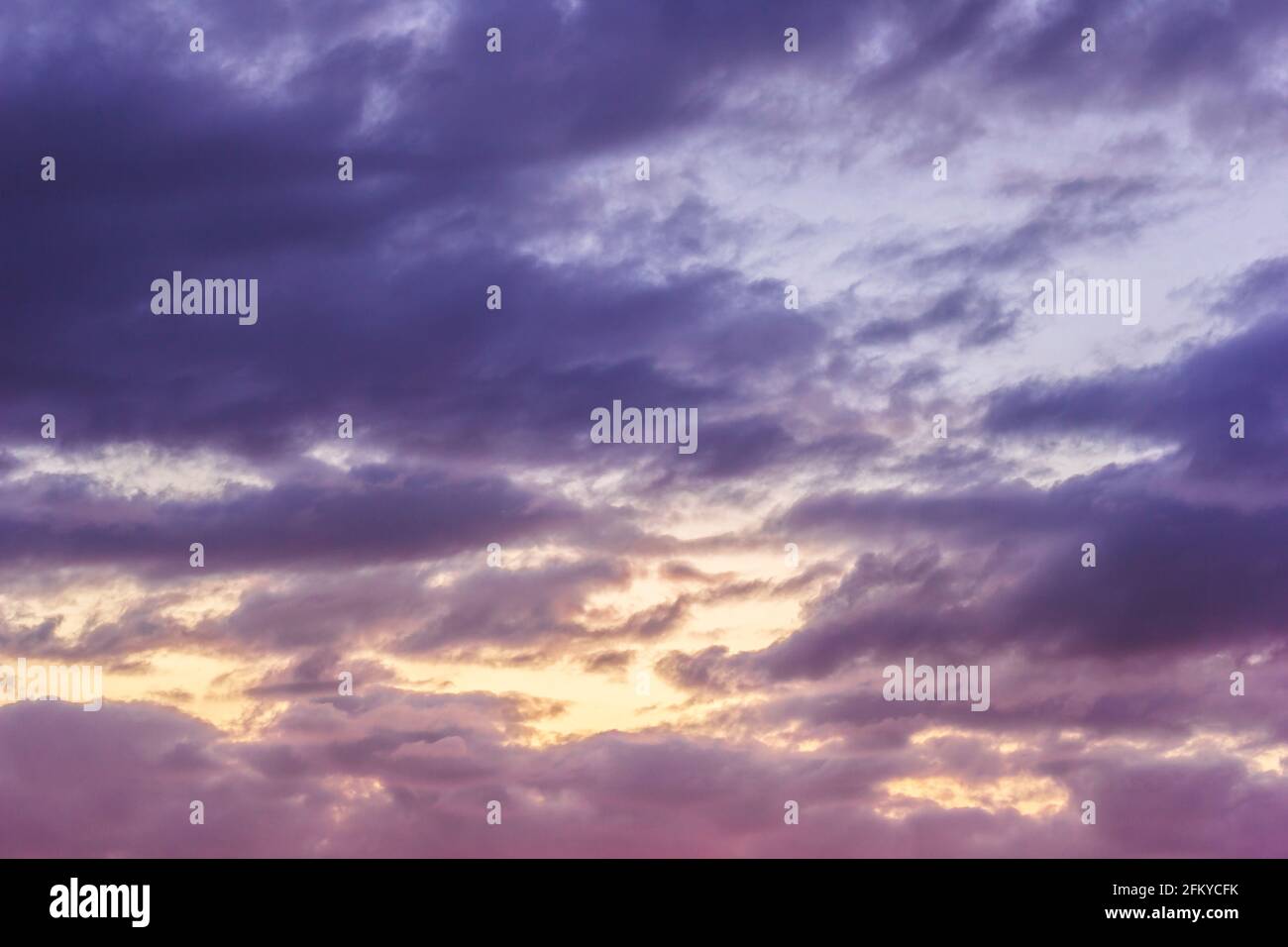 Sunset sky with clouds and sunbeams through wind clouds.  Stock Photo