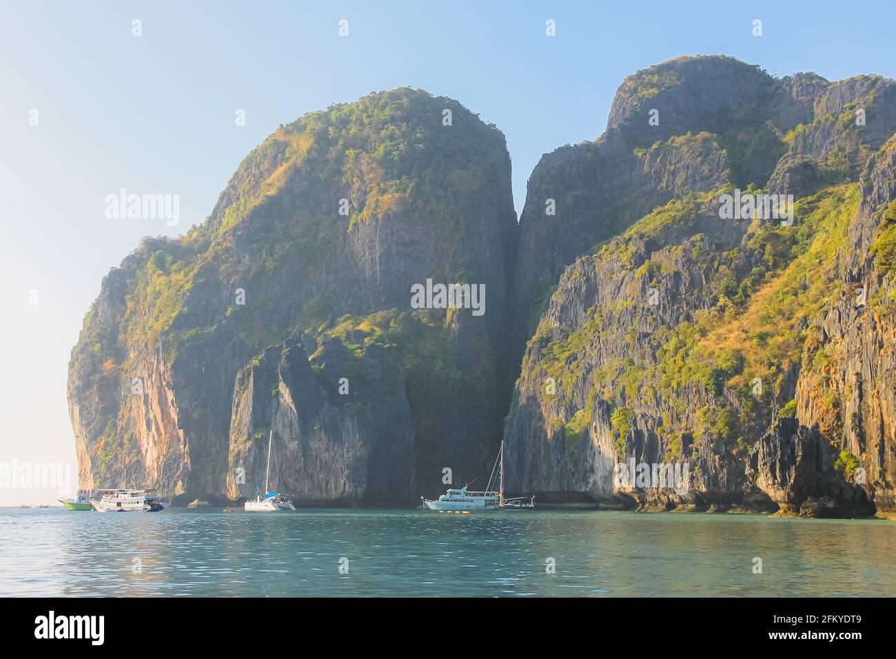 Idyllic limestone cliffs over tropical turquoise waters of the Andaman Sea on clear day at Maya Bay on Ko Phi Phi Lee in the Phi Phi islands in Thaila Stock Photo