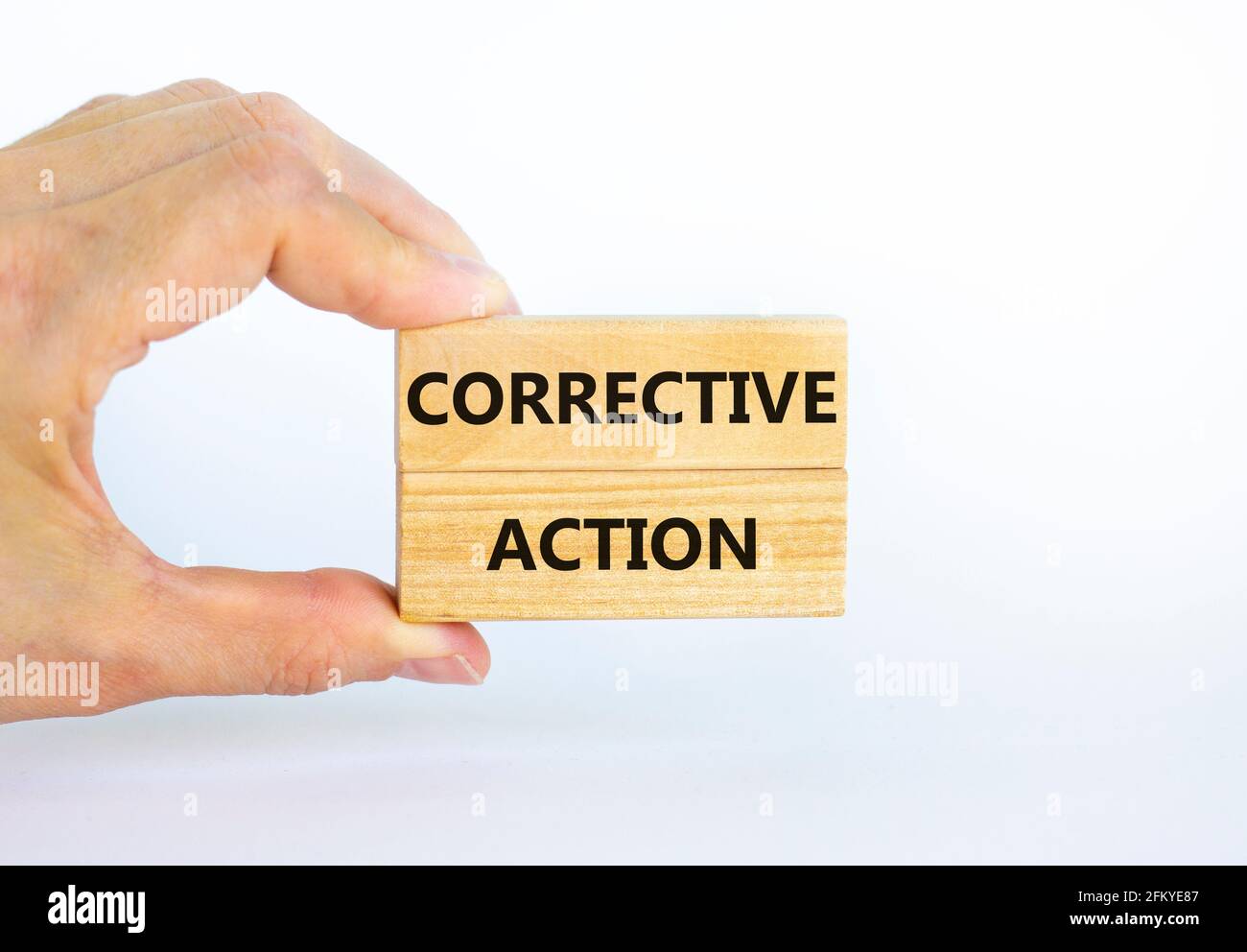 Corrective action symbol. Wooden blocks with words 'Corrective action' on beautiful white background. Businessman hand. Business and Corrective action Stock Photo